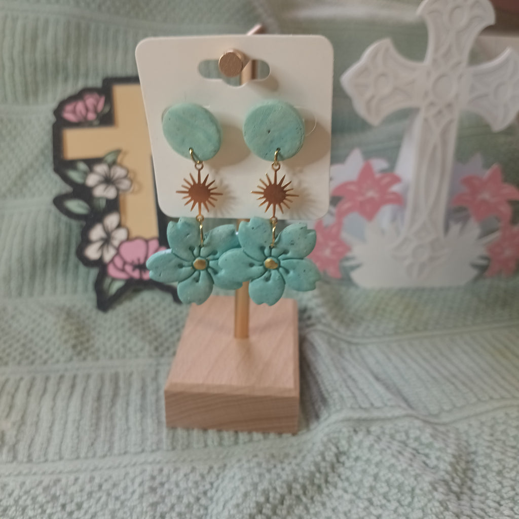 Sage green clay flower and starburst dangle earrings - front view